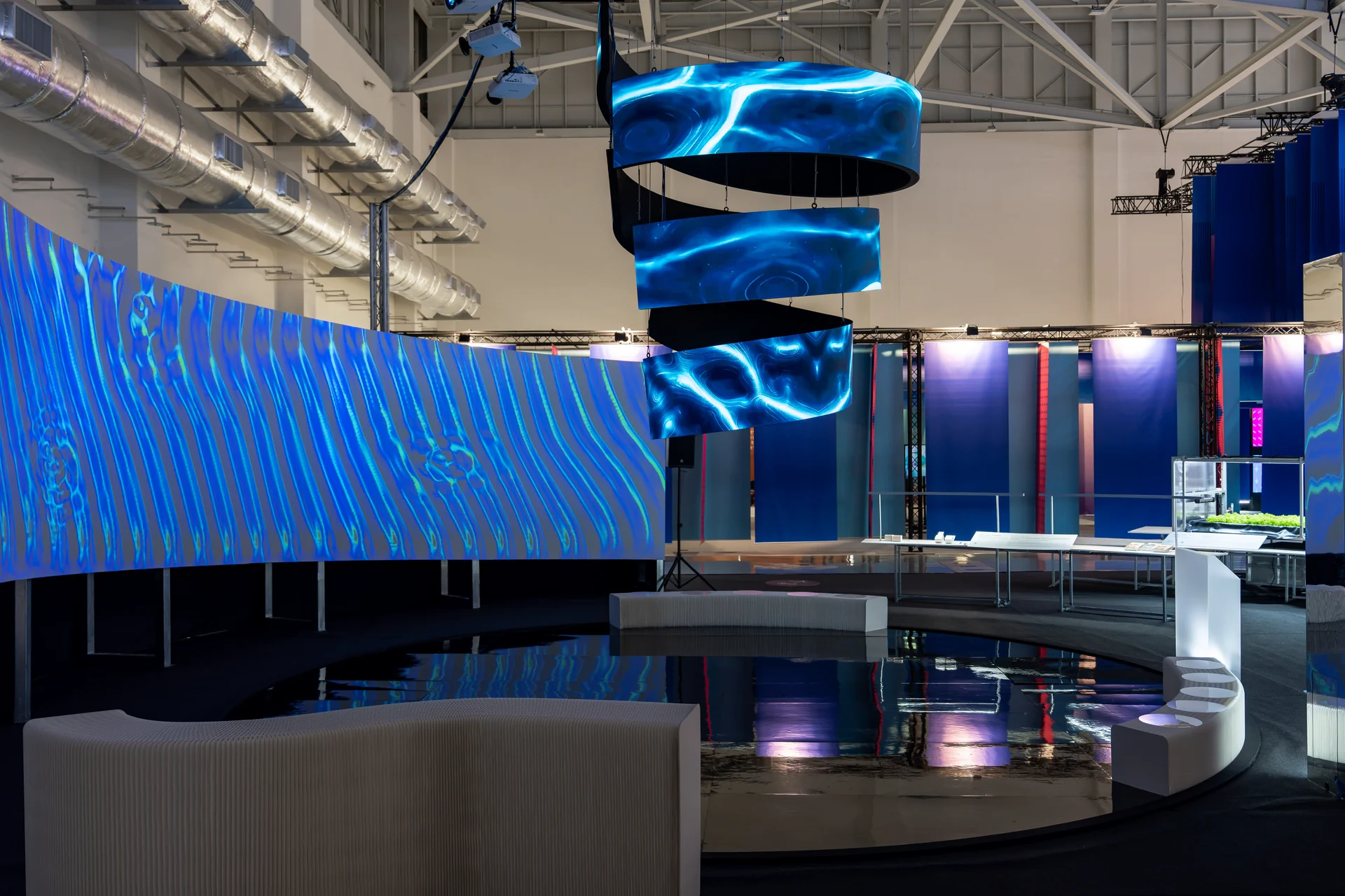 Cymatics of Life on site: The curved wall from the side, its blue light reflected below