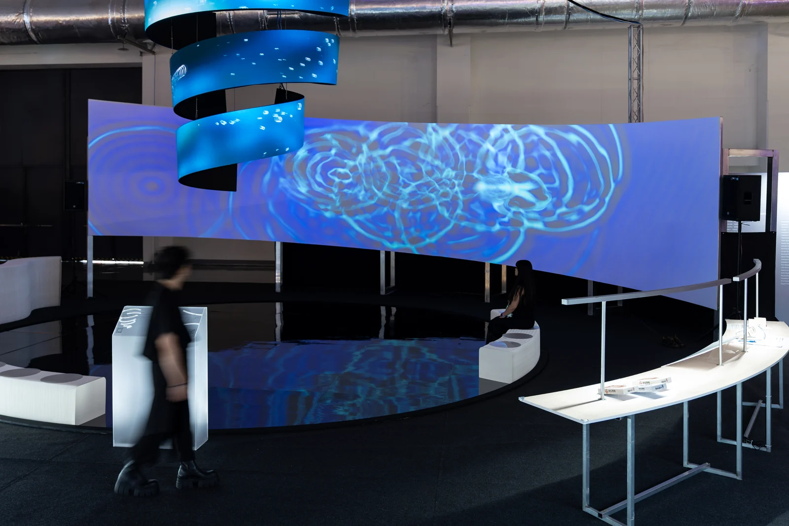 Cymatics of Life on site: Someone walking past as rings of ripples spread across the wall