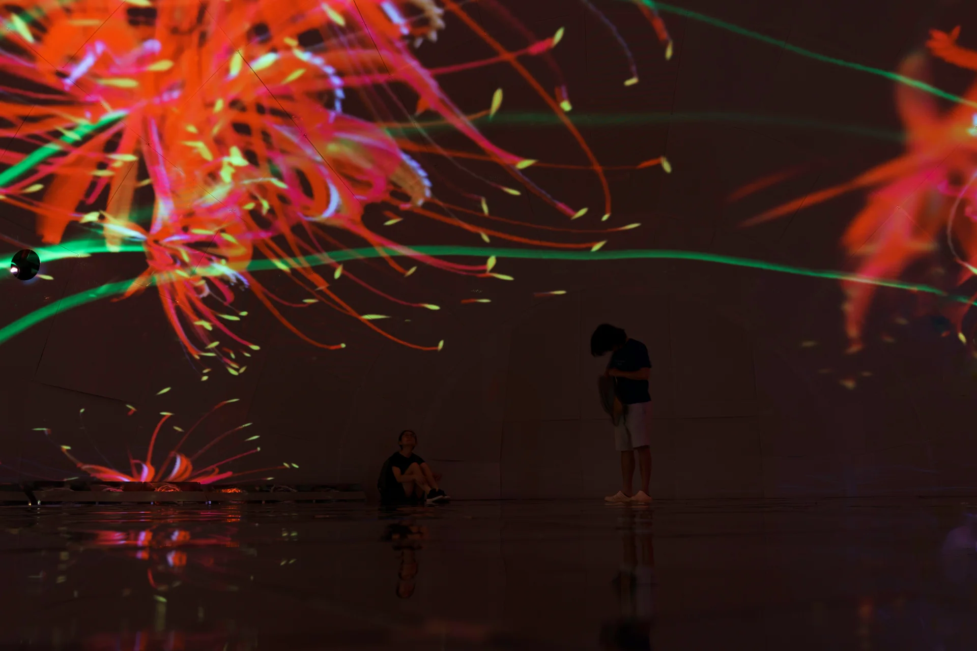 Orange spider lilies in the C-LAB dome, visitors on the mirrored floor