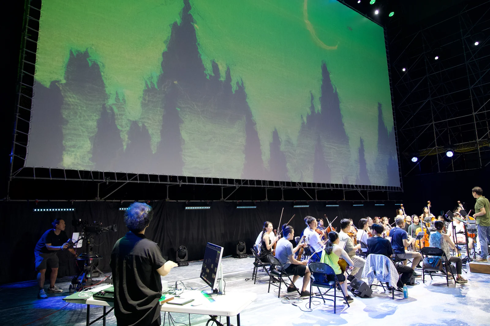 28 June rehearsal: Che-Yu Wu at the console, the orchestra and green mountains on the big screen