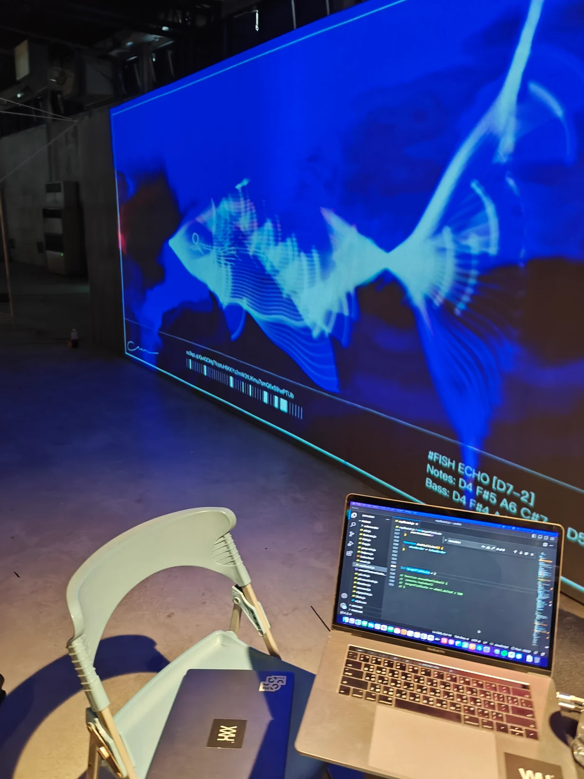 The first day on site: code on a laptop, a blue fish on the wall