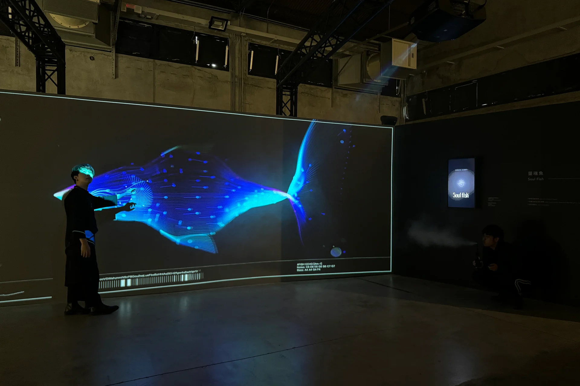 The day before closing, someone reaching toward a blue fish