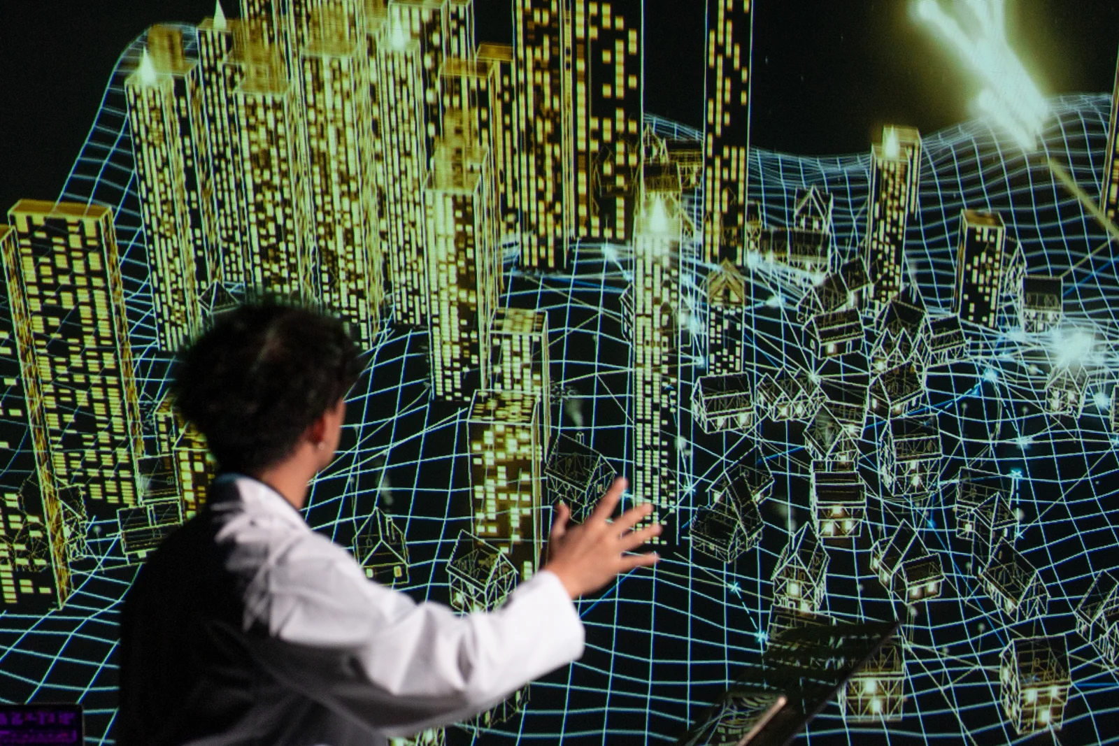 The Last Input rehearsal: the performer, back to the camera, reaching towards the wireframe city
