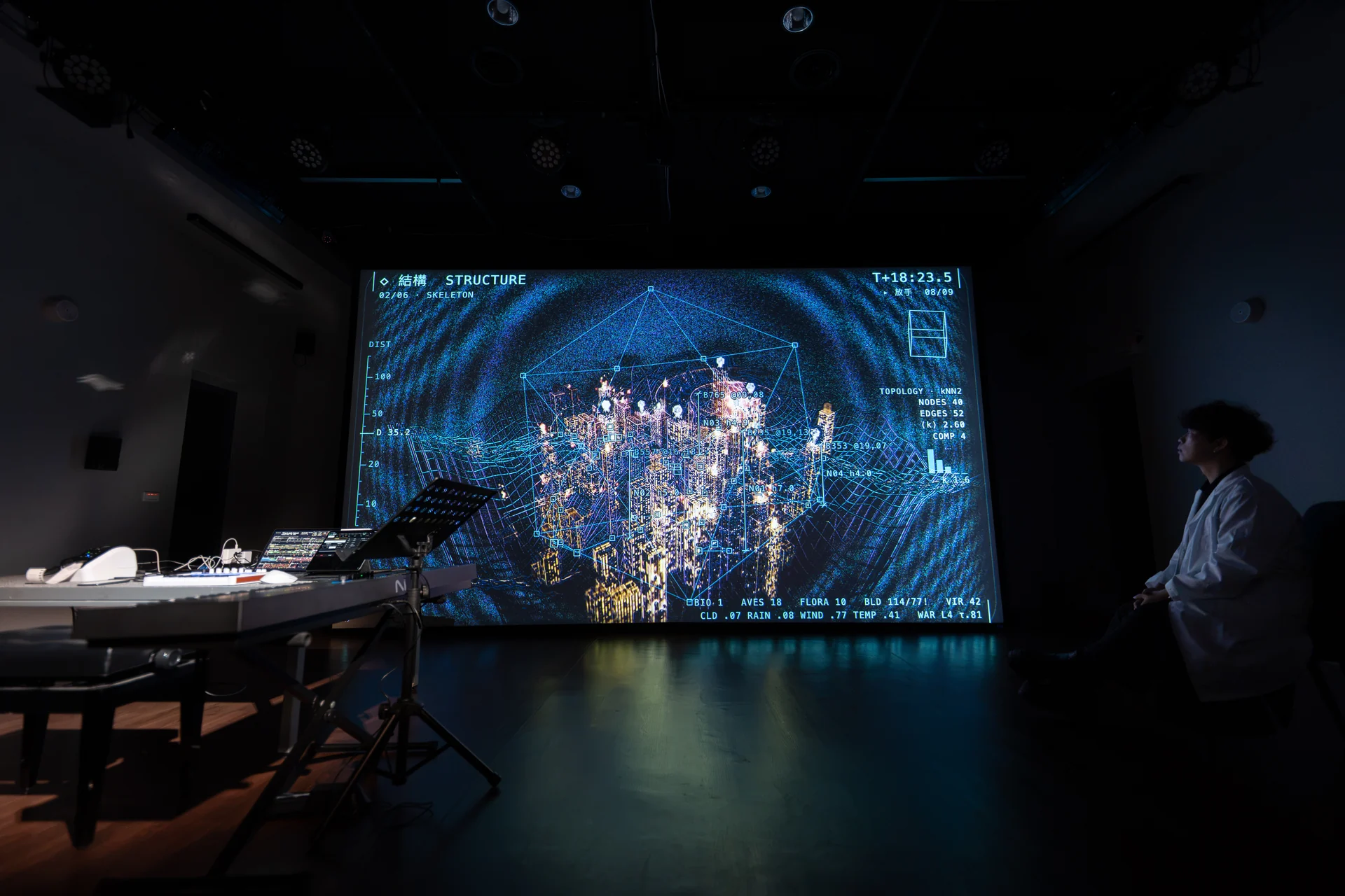 The Last Input rehearsal: the city under the structure lens, the performer watching from the side