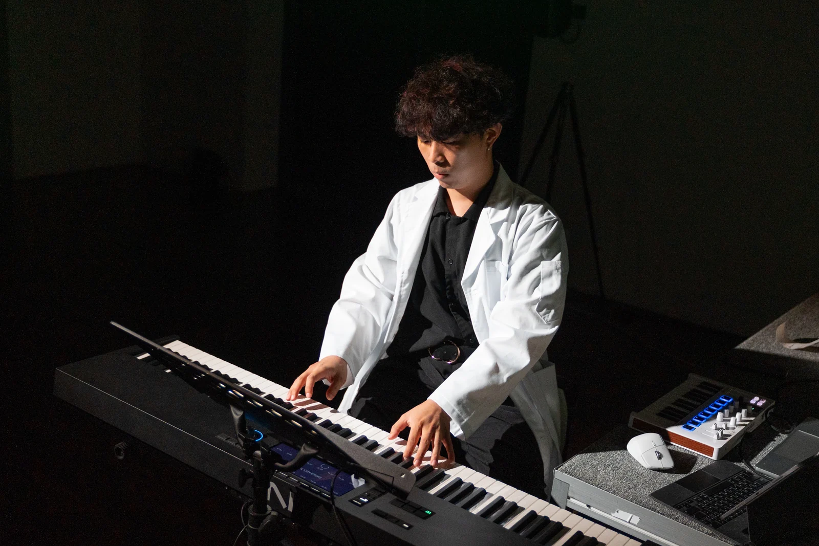 The Last Input rehearsal: the performer in a white coat playing, head down