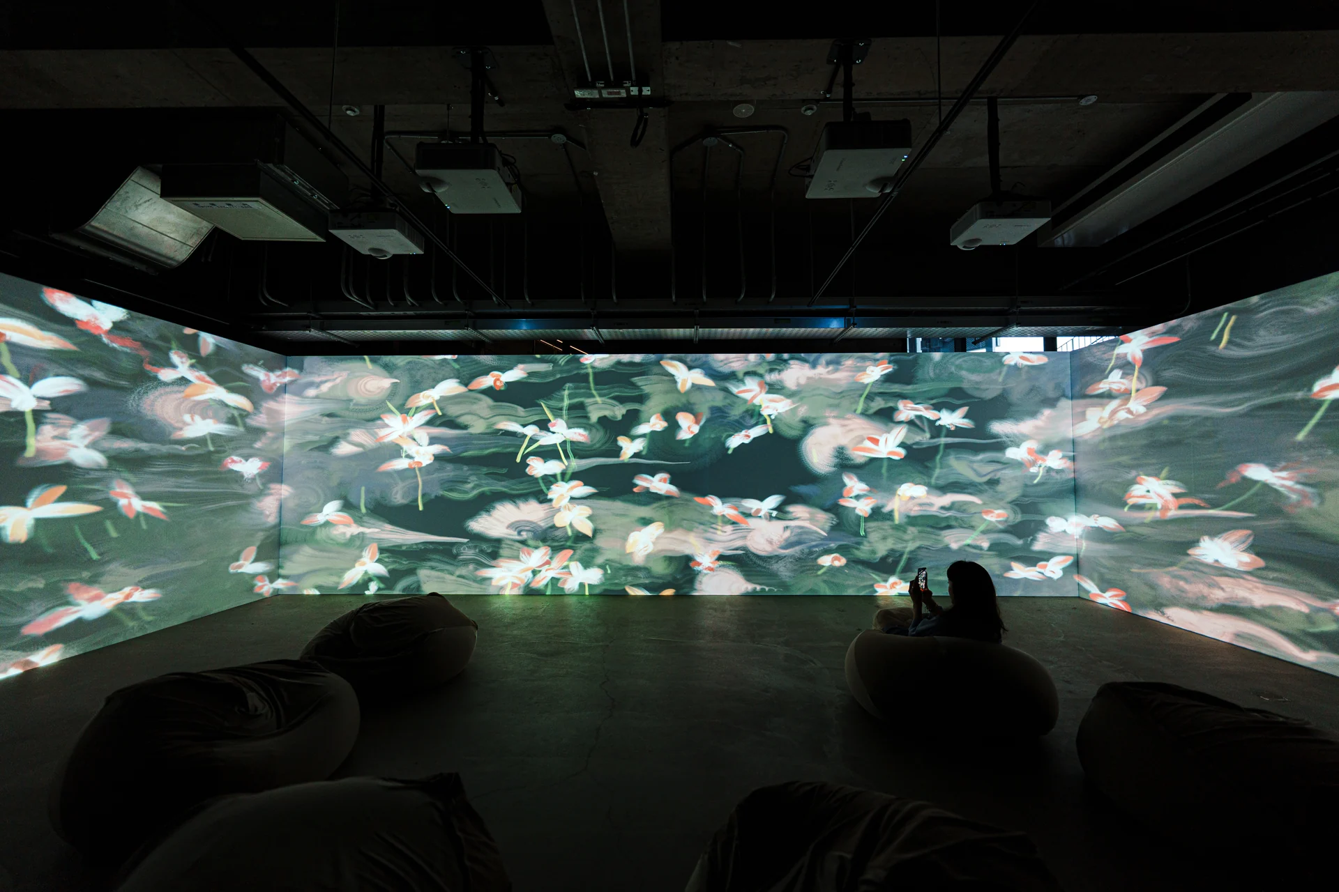White flowers across three walls, beanbags on the floor