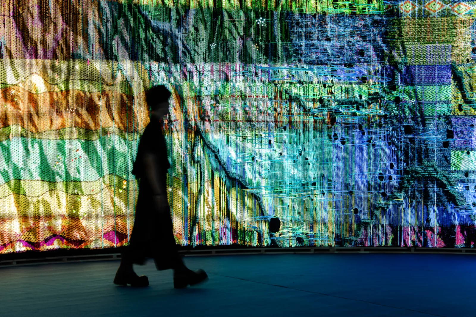 Woven Land, Woven River on site: A silhouette passing the cloth: the LEDs and the grain of the yarn